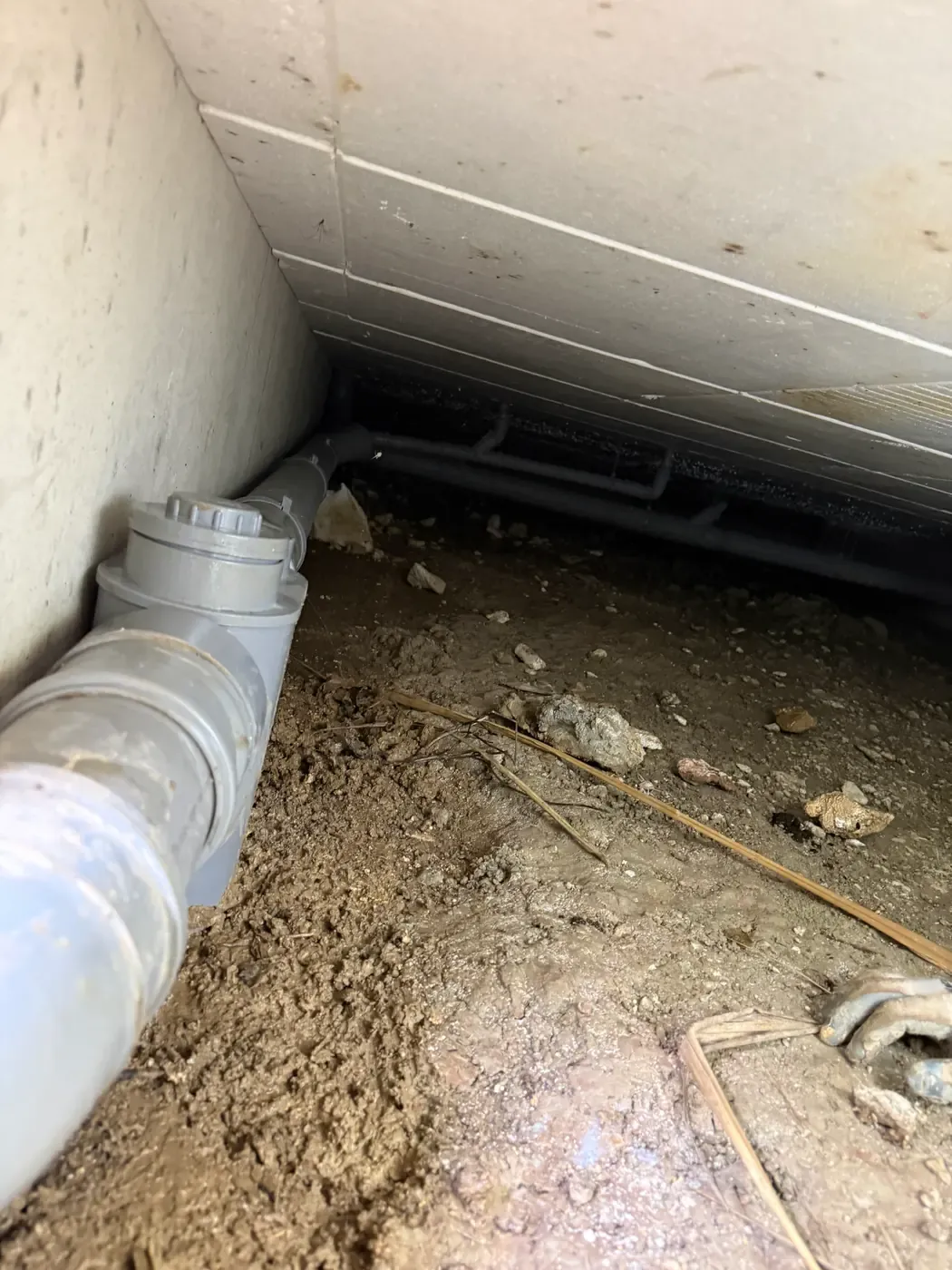 Réseau d’eaux usées et siphon disconnecteur sous le plancher de l’habitation à Opio