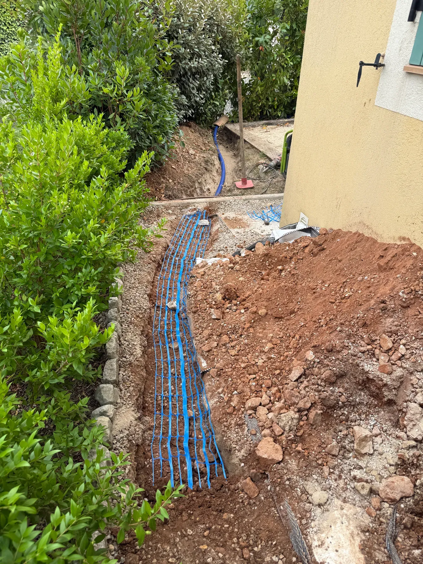 Grillage avertisseur bleu posé au-dessus d'une canalisation d'eau enterrée à Biot