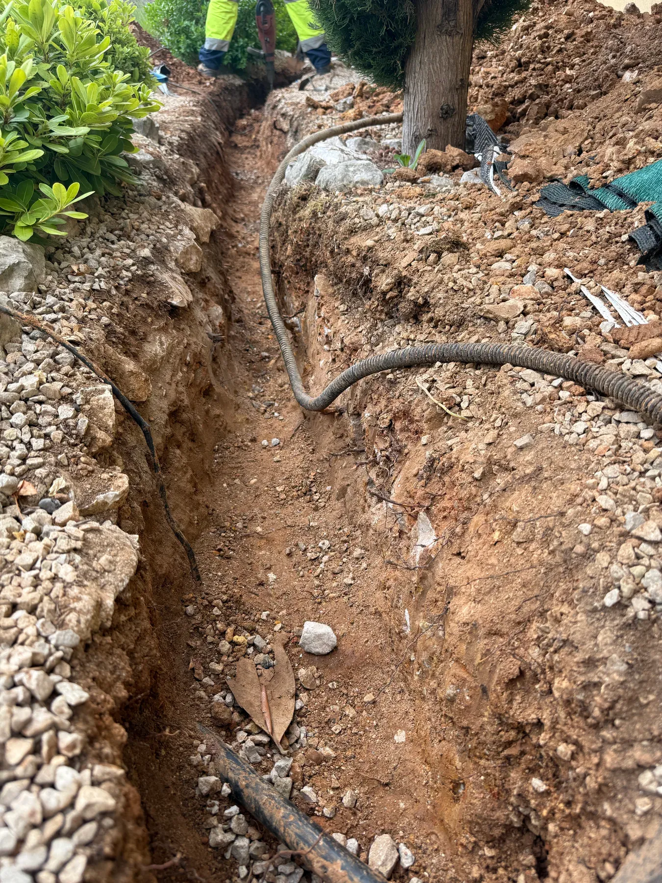 Tranchée ouverte dans un jardin pour remplacer une canalisation d'eau à Biot