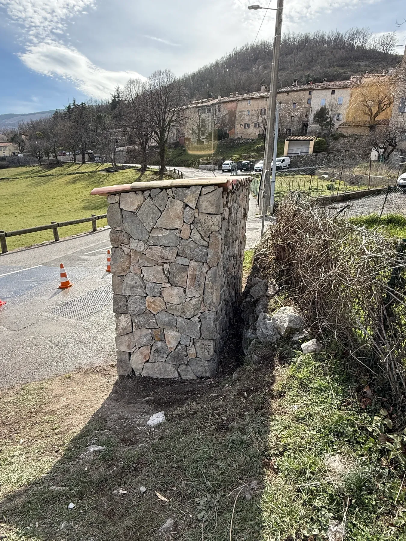 Pose du parement en pierre sur le local technique à Cipières