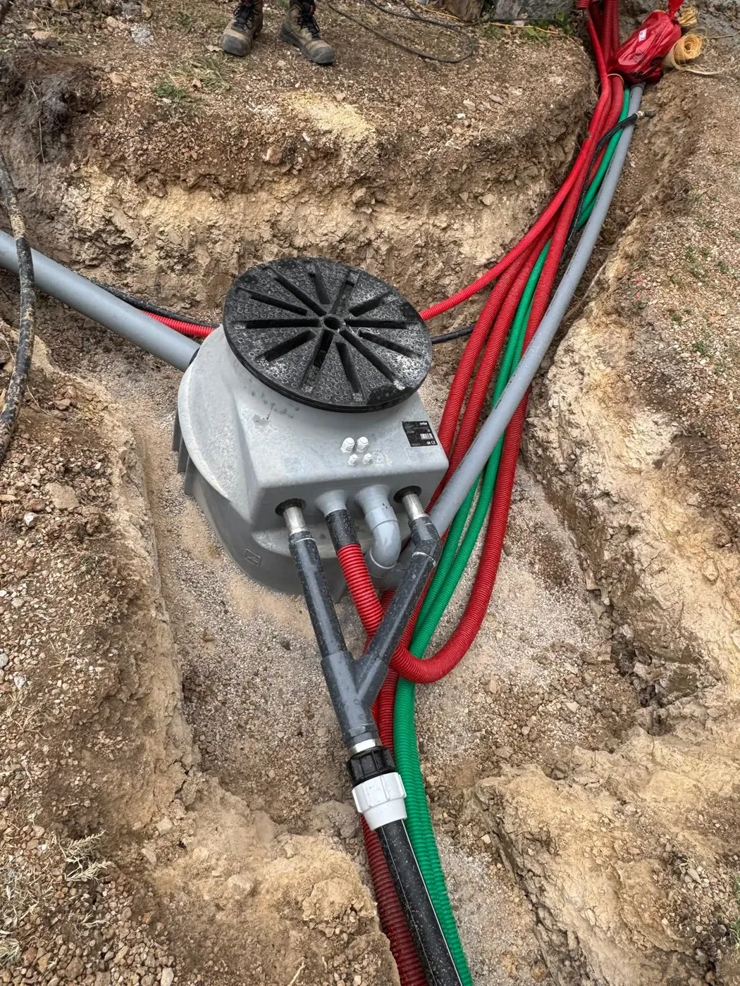 Poste de relevage dans sa fouille, avec conduites raccordées et gaines rouges et vertes à Châteauneuf-de-Grasse