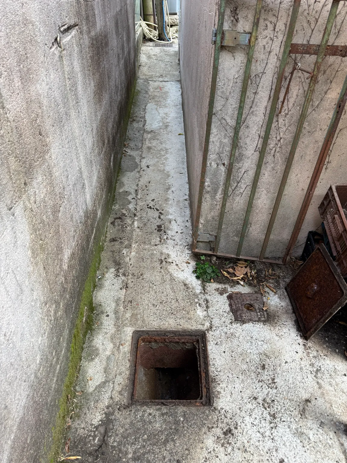 Regard d’évacuation ouvert dans un passage entre deux murs à Biot