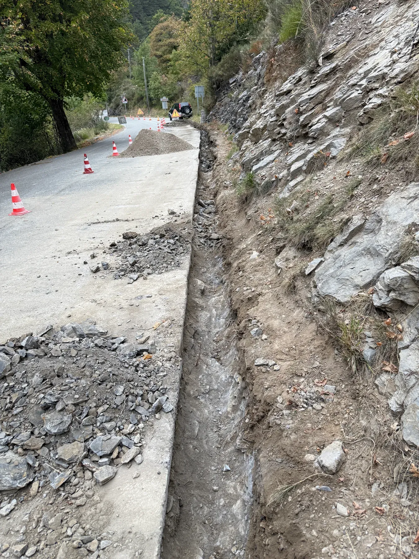 Tranchée ouverte le long d'une chaussée rocheuse pour un raccordement fibre à Venanson